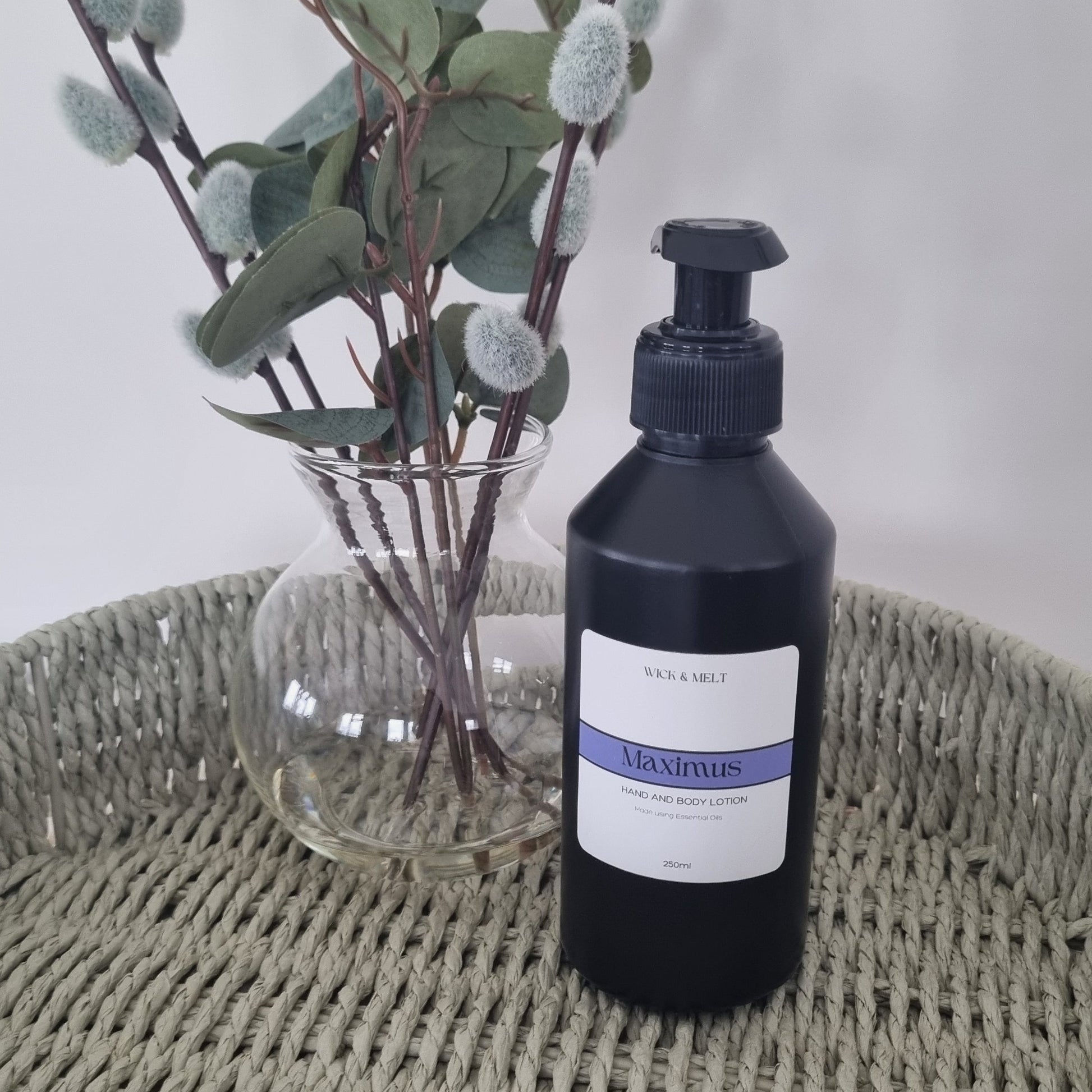 Bottle with a label next to a plant on a textured surface