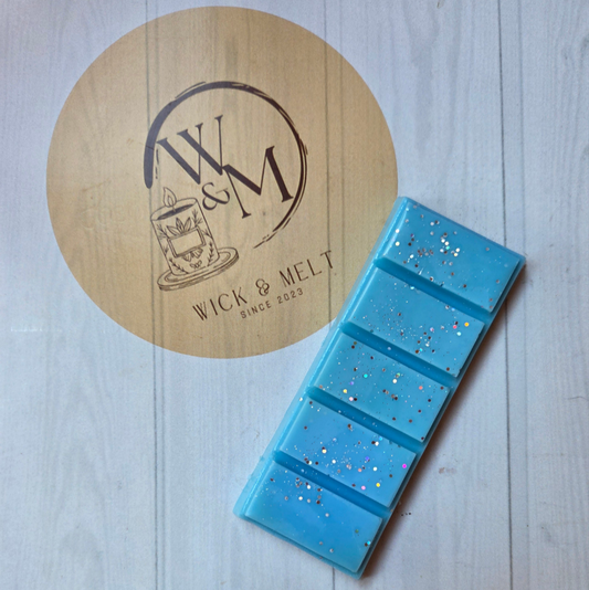 Blue wax bar with glitter on a wooden coaster with 'Wick & Melt' logo