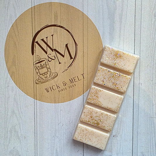 Wax bars on a wooden coaster with a visible brand logo on a light wood background